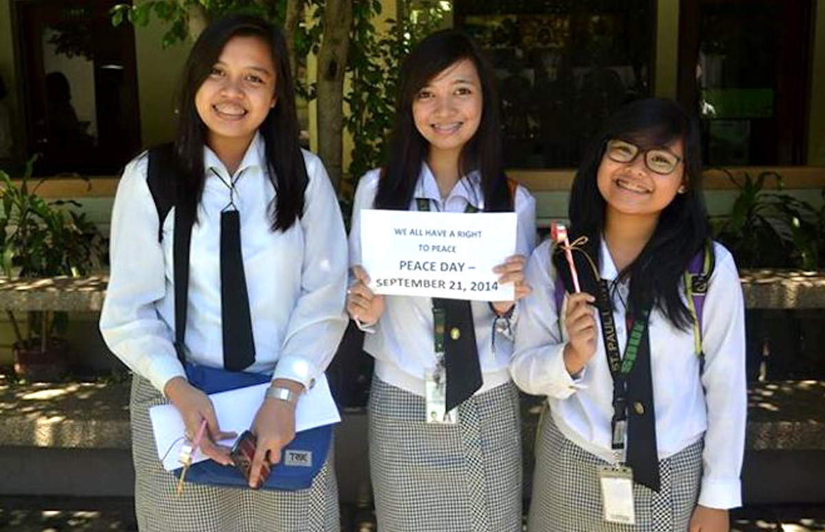 Three Peace Day participants holding a Right to Peace sign